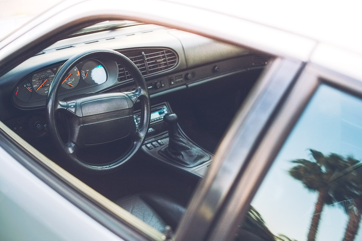 White 1987 Porsche 951interior and palm tree reflection