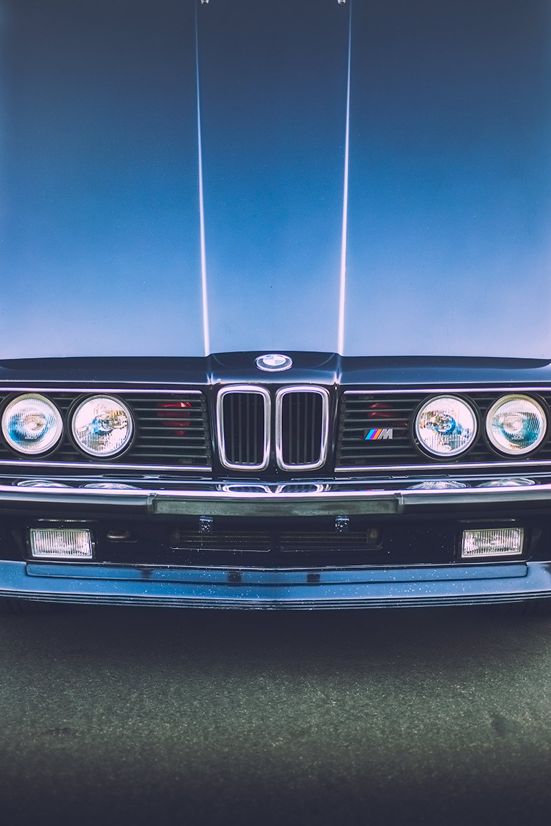 Morning light reflecting off the open hood of an 80s BMW e24 M6